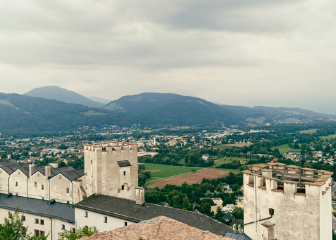 View of the historic Hohensalzburg Fortress towers overlooking the green valley and mountains of Salzburg Salzburg Austria. View of the historic Hohensalzburg Fortress towers overlooking the green valley and mountains of Salzburg Salzburg Austria.
