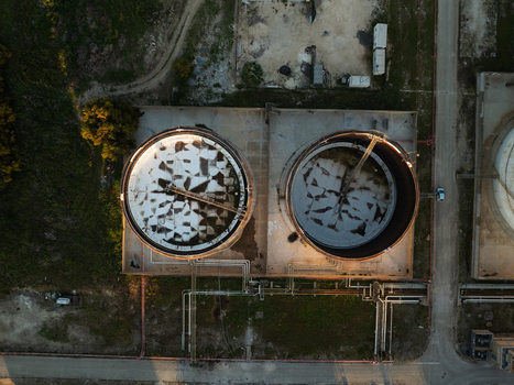 Aerial view of two large industrial storage tanks with weathered surfaces and complex piping systems in Augusta Sicily Italy. Aerial view of two large industrial storage tanks with weathered surfaces and complex piping systems in Augusta Sicily Italy.