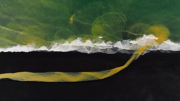 Aerial view of a yellow glacial river flowing into the ocean Iceland. Aerial view of a yellow glacial river flowing into the ocean Iceland.