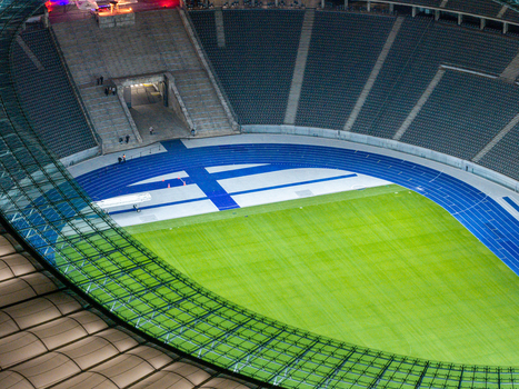 Berlin Germany 26 September 2026 Aerial view of Olympiastadion Berlin featuring its iconic blue running track lush green grass pitch and modern stadium seating.