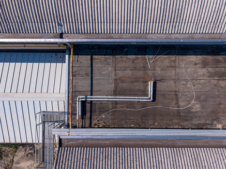 Aerial view of industrial building roof with corrugated metal panels metal pipes and a walkway in Casale Monferrato Piedmont Italy. Aerial view of industrial building roof with corrugated metal panels metal pipes and a walkway in Casale Monferrato Piedmont Italy.