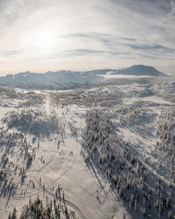 Aerial view of Gaustablikk Fjellresort surrounded by snow covered pine forests and mountains under a bright winter sky in Rjukan Telemark Norway. Aerial view of Gaustablikk Fjellresort surrounded by snow covered pine forests and mountains under a bright winter sky in Rjukan Telemark Norway.