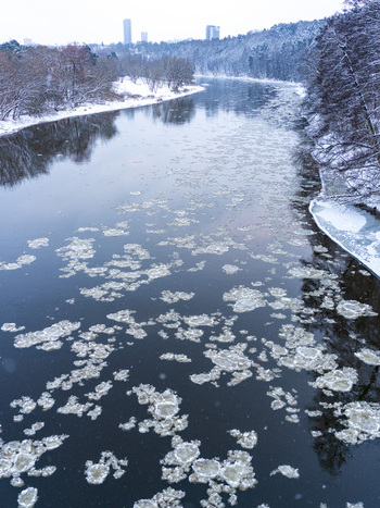 Aerial view of the Neris River in winter with floating ice floes snow covered banks and the distant skyline of Vilnius Vilnius County Lithuania. Aerial view of the Neris River in winter with floating ice floes snow covered banks and the distant skyline of Vilnius Vilnius County Lithuania.