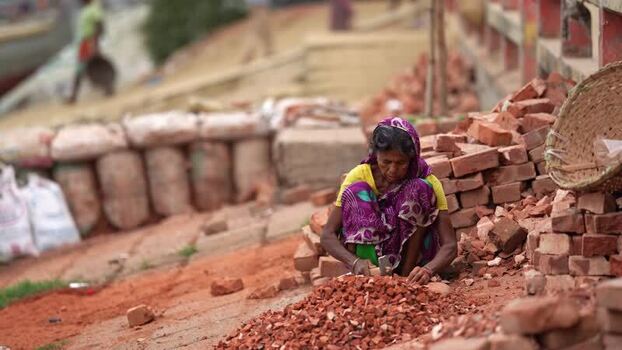View of a woman breaking bricks in Aminbazar Bangladesh. View of a woman breaking bricks in Aminbazar Bangladesh.