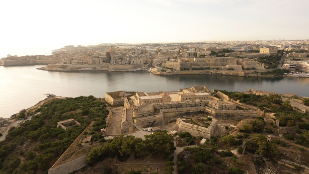 Aerial view of Fort Manoel a historic star fort surrounded by greenery with the Valletta skyline and the Grand Harbour in the background Malta. Aerial view of Fort Manoel a historic star fort surrounded by greenery with the Valletta skyline and the Grand Harbour in the background Malta.