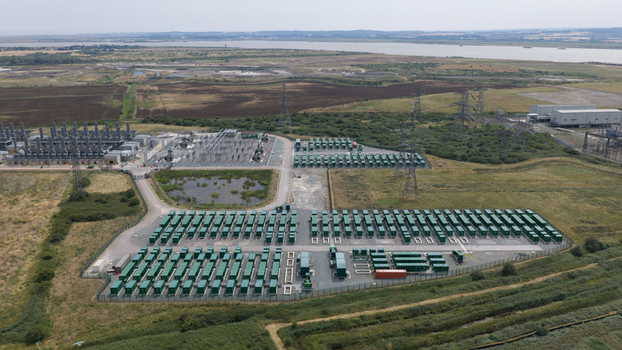 Aerial view of Thurrock Flexible Generation Substation with rows of green battery storage containers and electrical infrastructure in a rural landscape in Tilbury England United Kingdom.