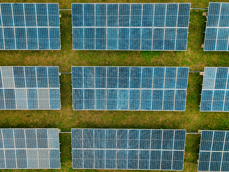 Aerial view of rows of solar panels installed in a grassy field in Ogun State Nigeria.