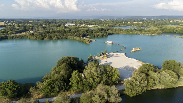 Aerial view of the Extraccion de aridos Lima S.L. quarry site with turquoise water and industrial equipment surrounded by lush green vegetation Vilarino das Poldras Ourense Spain. Aerial view of the Extraccion de aridos Lima S.L. quarry site with turquoise water and industrial equipment surrounded by lush green vegetation Vilarino das Poldras Ourense Spain.