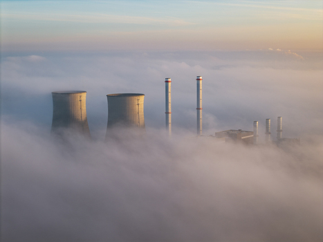 Aerial view of RWE Clauscentrale power plant with cooling towers and chimneys rising above a thick layer of morning fog in Maasbracht Limburg Netherlands. Aerial view of RWE Clauscentrale power plant with cooling towers and chimneys rising above a thick layer of morning fog in Maasbracht Limburg Netherlands.