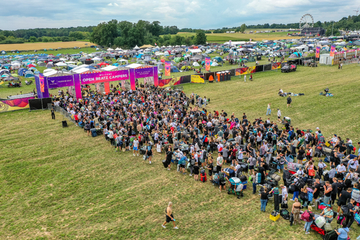 Herzogenaurach Germany 25 July 2025 Aerial view of the Open Beatz Festival entrance with a large crowd of campers queuing near tents and a distant Ferris wheel. Herzogenaurach Germany 25 July 2025 Aerial view of the Open Beatz Festival entrance with a large crowd of campers queuing near tents and a distant Ferris wheel.