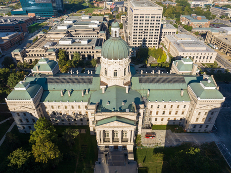 Aerial view of the Indiana Statehouse featuring its iconic green copper dome and neoclassical architecture surrounded by urban buildings in Indianapolis Indiana United States. Aerial view of the Indiana Statehouse featuring its iconic green copper dome and neoclassical architecture surrounded by urban buildings in Indianapolis Indiana United States.