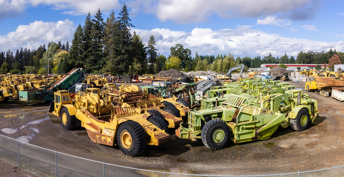 Woodburn United States 25 September 2026 Aerial view of a collection of heavy construction machinery including yellow and green Caterpillar scrapers parked in an industrial yard. Woodburn United States 25 September 2026 Aerial view of a collection of heavy construction machinery including yellow and green Caterpillar scrapers parked in an industrial yard.