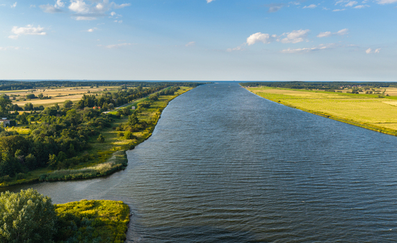 Aerial view of the Vistula River flowing through the lush green landscape and agricultural fields of Pomeranian Voivodeship Poland. Aerial view of the Vistula River flowing through the lush green landscape and agricultural fields of Pomeranian Voivodeship Poland.