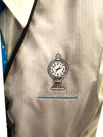 New York United States 14 May 2026 View of an embroidered Grand Central logo featuring the iconic clock on a grey uniform vest with a white collar and blue tie. New York United States 14 May 2026 View of an embroidered Grand Central logo featuring the iconic clock on a grey uniform vest with a white collar and blue tie.