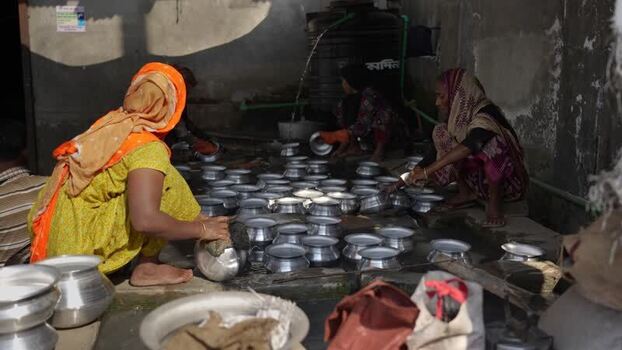 View of women washing metal pots in Bogura Bangladesh.
