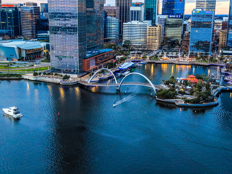 Aerial view of Elizabeth Quay with its iconic pedestrian bridge modern skyscrapers and a boat on the Swan River in Perth Western Australia Australia.