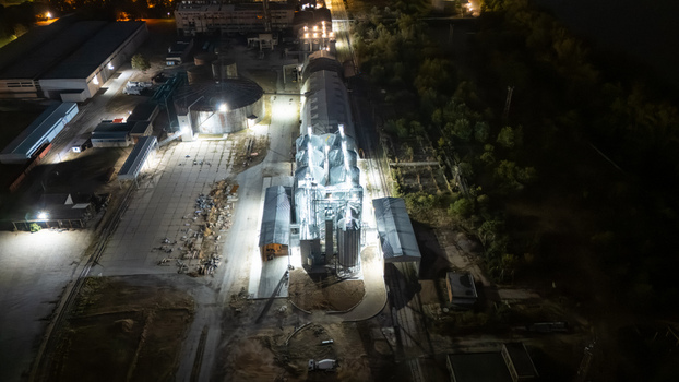 Aerial view of an illuminated industrial facility with grain silos and factory buildings at night in Sremska Mitrovica Vojvodina Serbia.