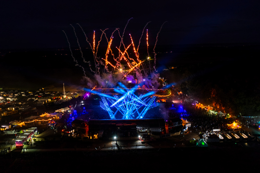 Herzogenaurach Germany 24 July 2025 Aerial view of the Open Beatz Festival with fireworks exploding in the night sky blue laser light show and a large crowd of people.