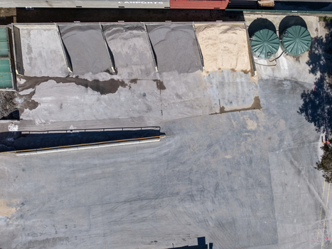 Aerial view of industrial storage bays containing gravel and sand adjacent to large green water tanks and a paved yard in Kilsyth Victoria Australia. Aerial view of industrial storage bays containing gravel and sand adjacent to large green water tanks and a paved yard in Kilsyth Victoria Australia.