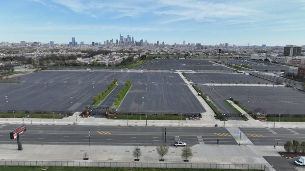 Aerial view of vast parking lots stretching towards the distant skyline a stark contrast against the sparse greenery Philadelphia Pennsylvania United States.