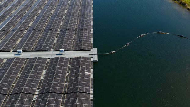 Aerial view of a large array of floating solar panels on a calm lake with a connecting cable and dark blue water Zwolle Overijssel Netherlands. Aerial view of a large array of floating solar panels on a calm lake with a connecting cable and dark blue water Zwolle Overijssel Netherlands.