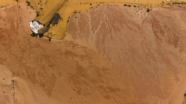 Aerial view of the textured landscape near Useless Loop featuring intricate patterns of sand and salt deposits in shades of yellow and brown in Kalbarri Western Australia Australia. Aerial view of the textured landscape near Useless Loop featuring intricate patterns of sand and salt deposits in shades of yellow and brown in Kalbarri Western Australia Australia.