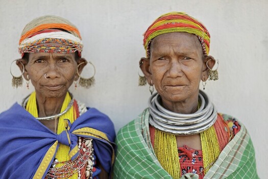 Odisha India 26 March 2026 View of two tribal women adorned in vibrant traditional attire their faces etched with wisdom and resilience standing against a simple backdrop. Odisha India 26 March 2026 View of two tribal women adorned in vibrant traditional attire their faces etched with wisdom and resilience standing against a simple backdrop.