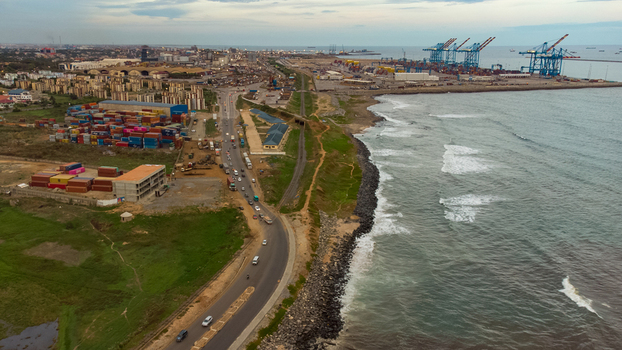 Aerial view of the Accra Tema Beach Road with a busy container terminal large port cranes and coastal traffic in Accra Greater Accra Region Ghana.