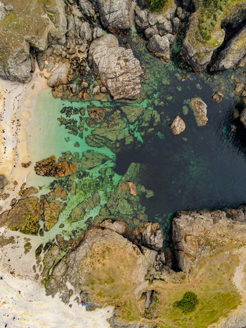 Aerial view of the rugged coastline and turquoise waters at Pointe des Poulains featuring jagged rock formations sandy coves and clear sea in Sauzon Bretagne France. Aerial view of the rugged coastline and turquoise waters at Pointe des Poulains featuring jagged rock formations sandy coves and clear sea in Sauzon Bretagne France.