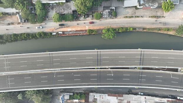 Aerial view of an elevated highway spanning over a river with surrounding urban infrastructure Bekasi Barat West Java Indonesia. Aerial view of an elevated highway spanning over a river with surrounding urban infrastructure Bekasi Barat West Java Indonesia.