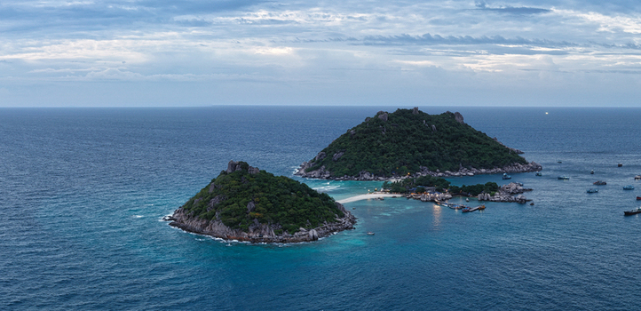 Aerial view of Nang Yuan Island with its iconic sandbar connecting two lush green rocky hills surrounded by turquoise waters and boats Ko Tao Surat Thani Thailand.