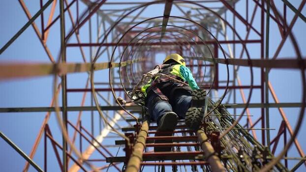 View of a technician climbing a telecommunications tower Bangladesh. View of a technician climbing a telecommunications tower Bangladesh.