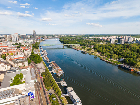 Aerial view of the Danube river with bridges and docked boats under a blue sky in Bratislava Bratislava Region Slovakia. Aerial view of the Danube river with bridges and docked boats under a blue sky in Bratislava Bratislava Region Slovakia.