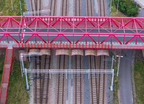 Aerial view of the red steel truss bridge spanning over railway tracks in the Letnica district of Gdansk Pomeranian Voivodeship Poland. Aerial view of the red steel truss bridge spanning over railway tracks in the Letnica district of Gdansk Pomeranian Voivodeship Poland.