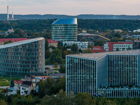 Aerial view of the modern business district with glass skyscrapers and contemporary office buildings surrounded by lush greenery in Vilnius Vilnius County Lithuania. Aerial view of the modern business district with glass skyscrapers and contemporary office buildings surrounded by lush greenery in Vilnius Vilnius County Lithuania.