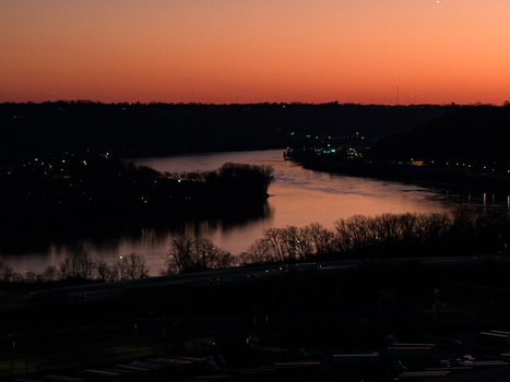 Aerial view of the river reflecting the warm hues of the sunset contrasting with the dark silhouettes of the trees Charleston West Virginia United States. Aerial view of the river reflecting the warm hues of the sunset contrasting with the dark silhouettes of the trees Charleston West Virginia United States.
