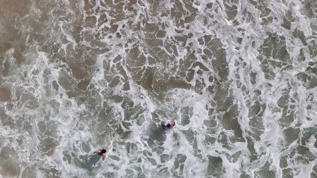 Aerial view of people swimming in waves at Copacabana Beach Brazil.