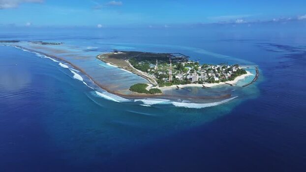 Aerial view of Thulusdhoo island and coral reefs Maldives.