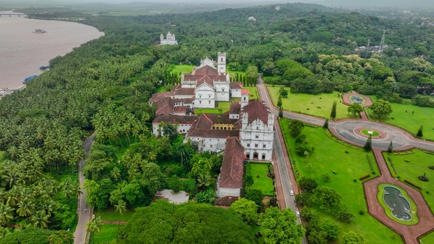 Aerial view of the Church of St. Francis of Assisi surrounded by lush green gardens palm trees and the Mandovi River in Old Goa Goa India. Aerial view of the Church of St. Francis of Assisi surrounded by lush green gardens palm trees and the Mandovi River in Old Goa Goa India.