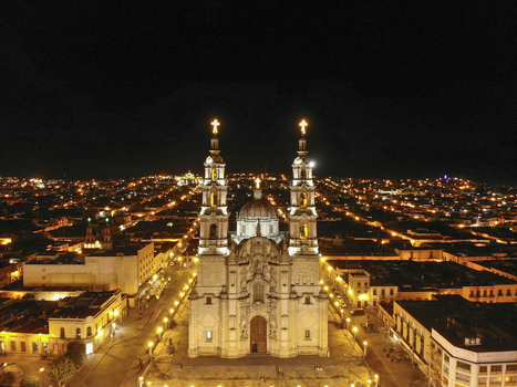 Aerial view of the Parish of Our Lady of the Assumption illuminated at night surrounded by the historic city center of Lagos de Moreno Jalisco Mexico.