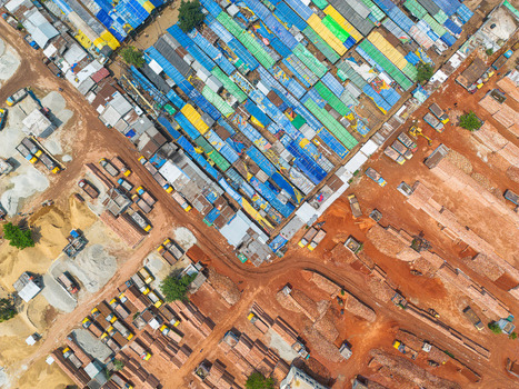 Aerial view of a neighborhood with colorful roofs juxtaposed against the red earth and brick structures Dhaka Dhaka Division Bangladesh. Aerial view of a neighborhood with colorful roofs juxtaposed against the red earth and brick structures Dhaka Dhaka Division Bangladesh.