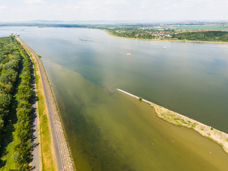 Aerial view of the Danube river with a long embankment a small sandbar and a cargo ship in the distance near Bratislava Bratislava Region Slovakia. Aerial view of the Danube river with a long embankment a small sandbar and a cargo ship in the distance near Bratislava Bratislava Region Slovakia.