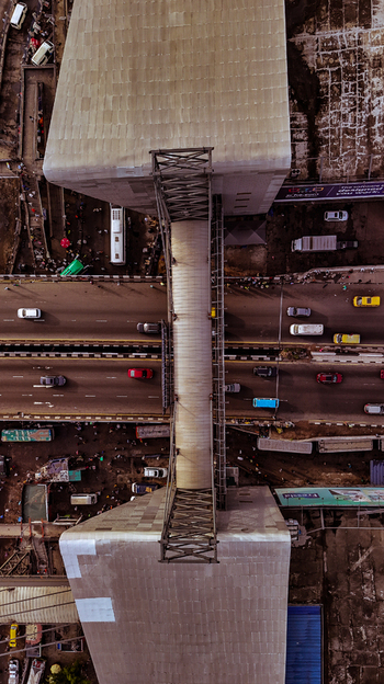 Aerial view of a concrete bridge pier standing tall above the bustling highway splitting the urban landscape Lagos Nigeria. Aerial view of a concrete bridge pier standing tall above the bustling highway splitting the urban landscape Lagos Nigeria.