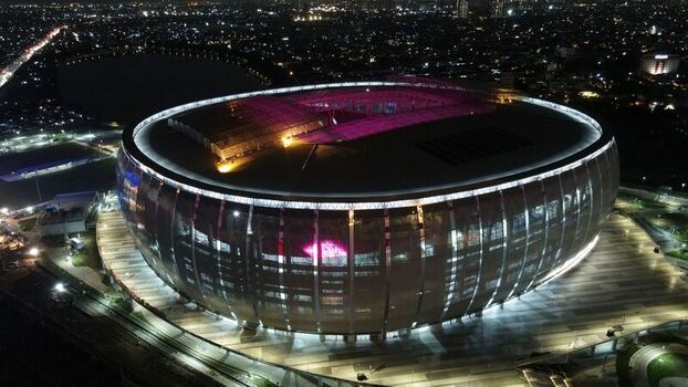 Aerial view of Jakarta International Stadium illuminated at night with vibrant lights showcasing its modern architectural design and surrounding urban landscape in Tanjung Priok Jakarta Indonesia. Aerial view of Jakarta International Stadium illuminated at night with vibrant lights showcasing its modern architectural design and surrounding urban landscape in Tanjung Priok Jakarta Indonesia.