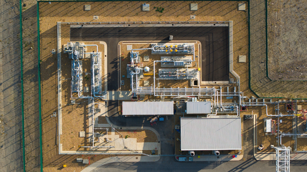 Aerial view of the Millbrook Power Plant featuring industrial piping storage tanks and facility buildings within a fenced perimeter in Stewartby England United Kingdom. Aerial view of the Millbrook Power Plant featuring industrial piping storage tanks and facility buildings within a fenced perimeter in Stewartby England United Kingdom.