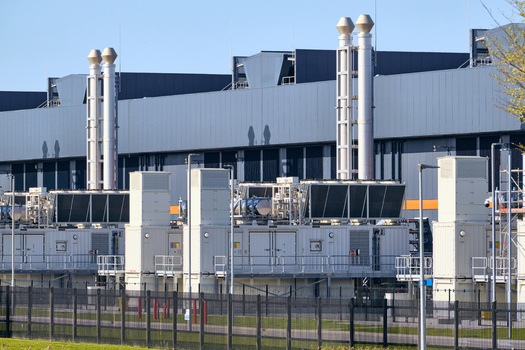 Middenmeer Netherlands 14 April 2026 View of the Microsoft datacenter AMS13 featuring large cooling units tall exhaust stacks and a security fence under a clear blue sky. Middenmeer Netherlands 14 April 2026 View of the Microsoft datacenter AMS13 featuring large cooling units tall exhaust stacks and a security fence under a clear blue sky.