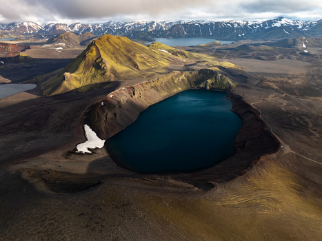 Aerial view of the volcanic crater lake Ljotipollur in Landmannalaugar featuring deep blue water rugged slopes and snow capped peaks in Rangarthing ytra Iceland. Aerial view of the volcanic crater lake Ljotipollur in Landmannalaugar featuring deep blue water rugged slopes and snow capped peaks in Rangarthing ytra Iceland.