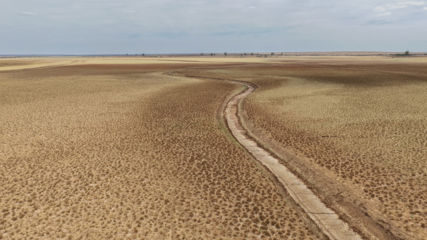 Aerial view of a vast drought stricken landscape with parched vegetation and a dry riverbed in Beaufort West Western Cape South Africa. Aerial view of a vast drought stricken landscape with parched vegetation and a dry riverbed in Beaufort West Western Cape South Africa.