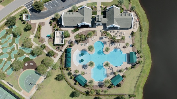 Aerial view of the Windward Ranch Boulevard community pool clubhouse miniature golf course and basketball court surrounded by lush landscaping in St. Johns County Florida United States. Aerial view of the Windward Ranch Boulevard community pool clubhouse miniature golf course and basketball court surrounded by lush landscaping in St. Johns County Florida United States.