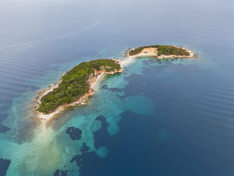 Aerial view of the Ksamil Islands surrounded by turquoise waters and lush green vegetation in the Ionian Sea Ksamil Vlore County Albania. Aerial view of the Ksamil Islands surrounded by turquoise waters and lush green vegetation in the Ionian Sea Ksamil Vlore County Albania.